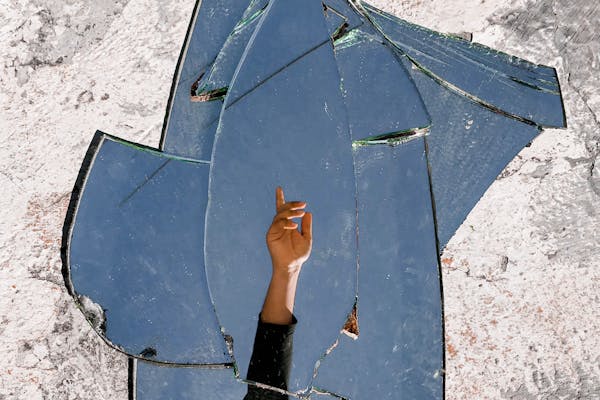 Mirror fragments reflecting a person's hand