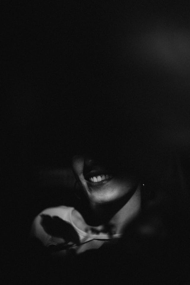 A woman smiling behind a shadow